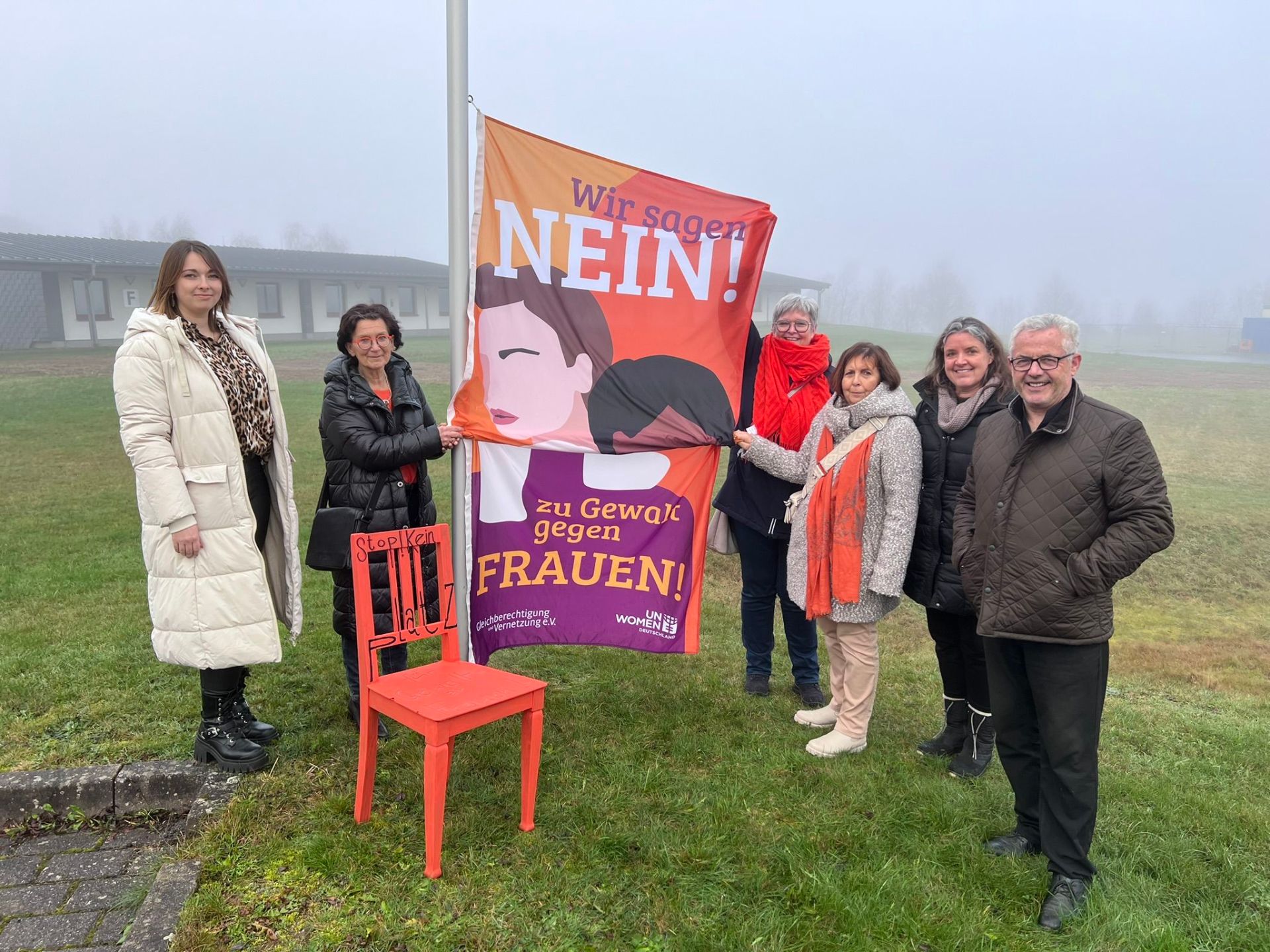 Gleichstellungsbeauftragte Vivien Schmitz, Cornelia Layaa-Laulhé, Birgit Bieler, Hiltrud Thiel, Kathrin Bröcker und Bürgermeister Albert Jung beim Hissen der Fahne vor der Verbandsgemeindeverwaltung Kaisersesch.