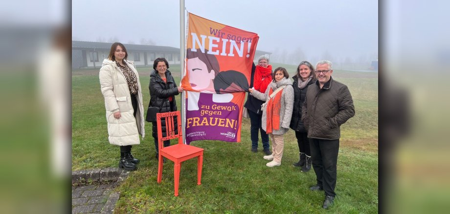 Gleichstellungsbeauftragte Vivien Schmitz, Cornelia Layaa-Laulhé, Birgit Bieler, Hiltrud Thiel, Kathrin Bröcker und Bürgermeister Albert Jung beim Hissen der Fahne vor der Verbandsgemeindeverwaltung Kaisersesch.