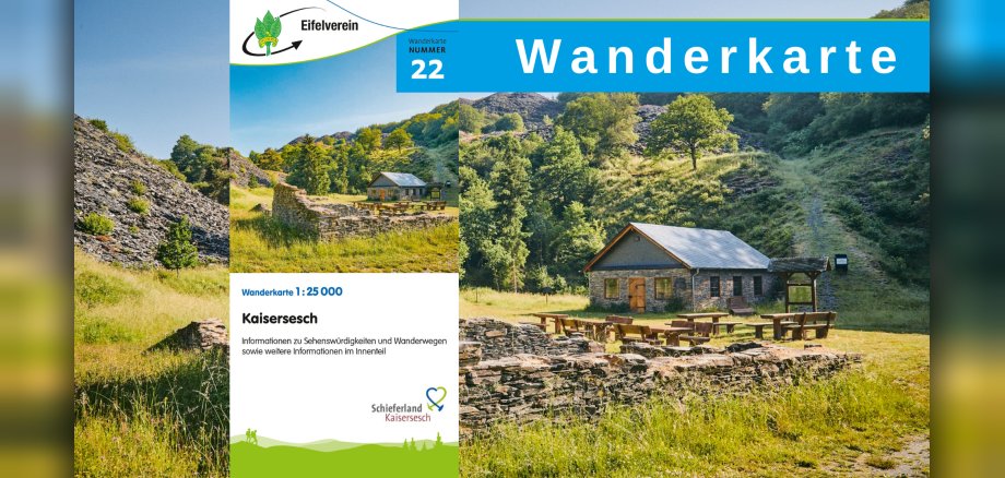 Hinweis auf die Wanderkarte mit Foto des Spalthauses im Kaulenbachtal Eine steinerne Ruine steht im Vordergrund eines Bildes, das das Spalthaus mit Sitzgelegenheiten im Freien vor einer bewaldeten Hügelkulisse (Kaulenbachtal) zeigt. Das Bild ist an einem sonnigen Tag aufgenommen und hat eine friedliche und rustikale Atmosphäre. Auf dem Foto liegt ein weiteres Foto, das die Wanderkarte mit der Nummer 22 zeigt.