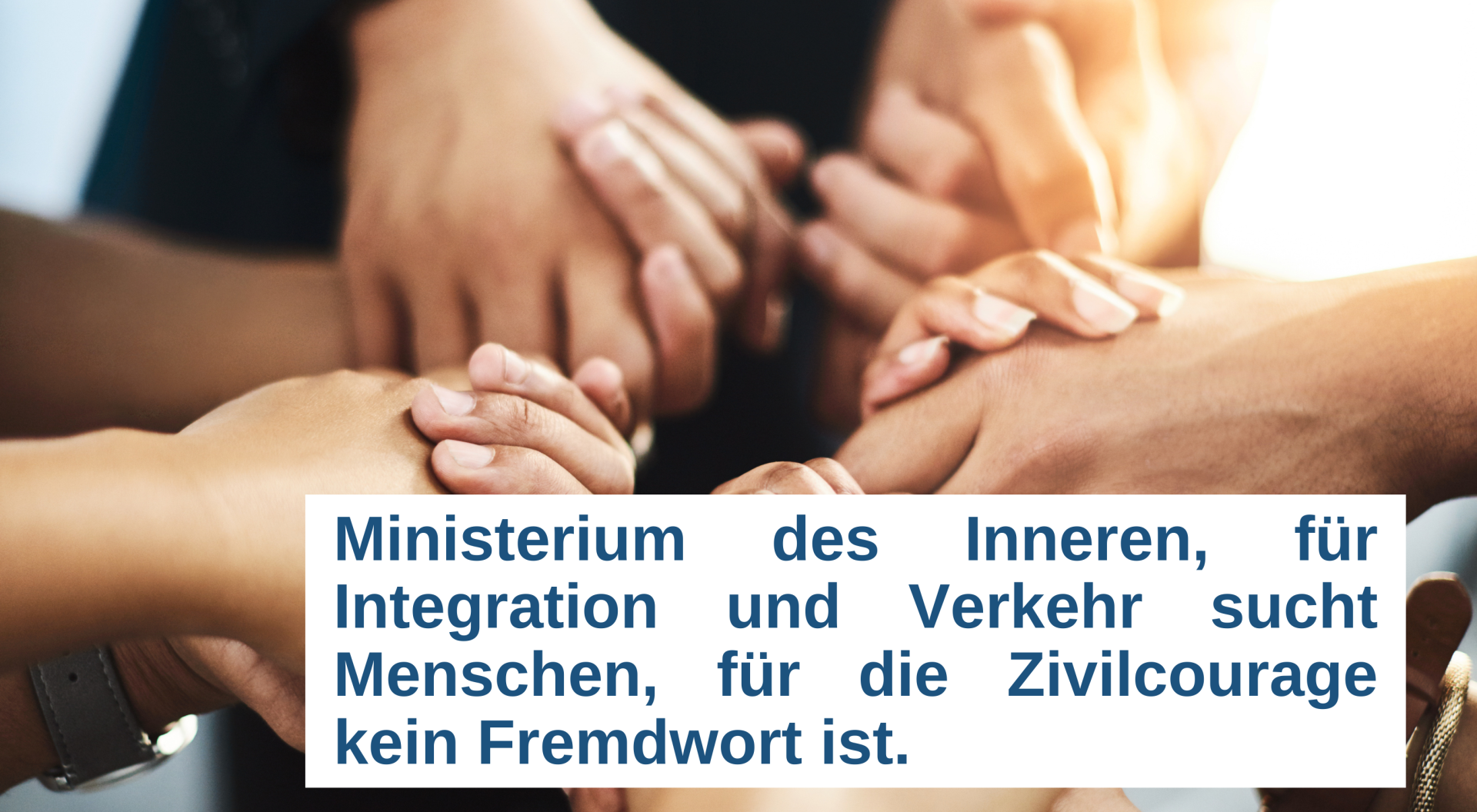Auf dem Foto sind Hände zu sehen, die sich gegenseitig halten. Davor steht in blauer Schrift in einem weißen Textfeld "Ministerium des Inneren, für Integration und Verkehr sucht Menschen, für die Zivilcourage kein Fremdwort ist. 