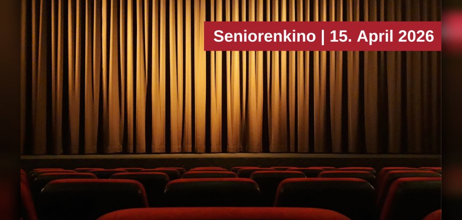 Das Bild zeigt einen Kinosaal mit roten Sitzen im Vordergrund und einem geschlossenen goldenen Vorhang im Hintergrund. Über dem Vorhang befindet sich ein roter Balken mit der weißen Aufschrift "Seniorenkino | 15. April 2026".
