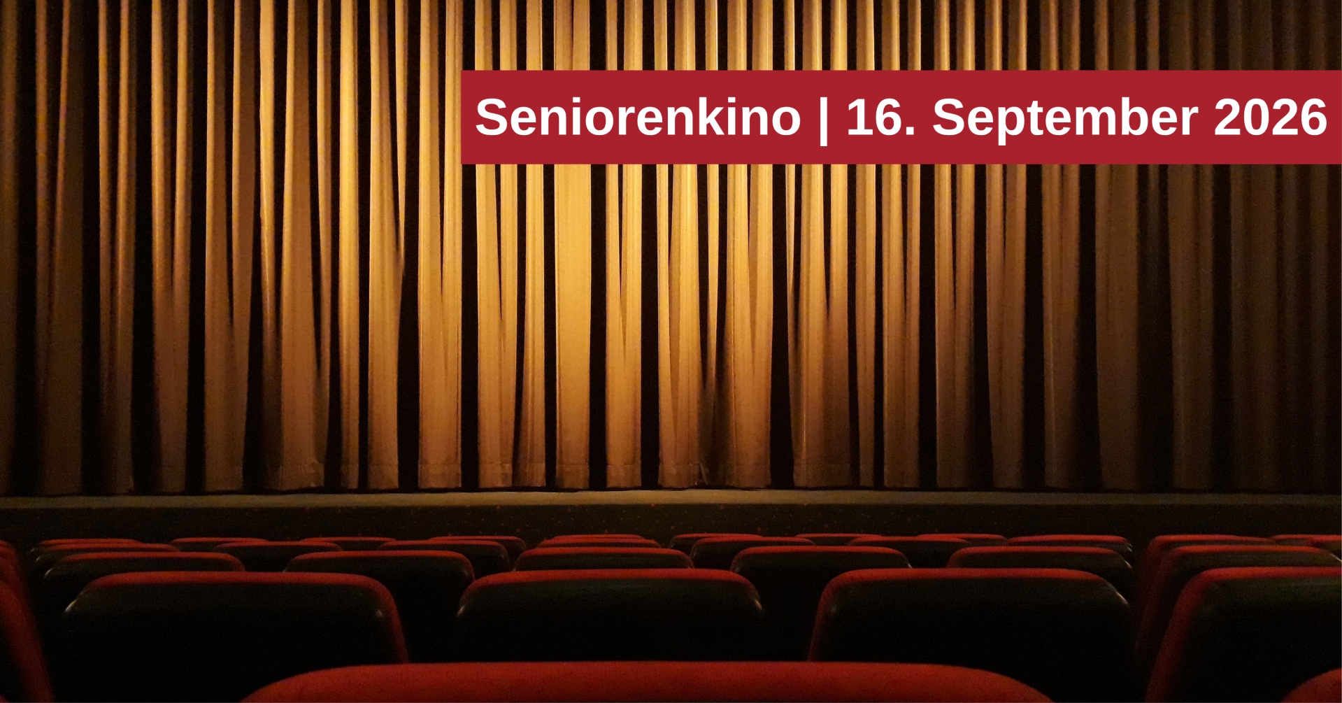 Leerer Kinosaal mit roten Sitzen und goldenem Vorhang. Ein Hinweis kündigt das Seniorenkino am 16. September 2026 an.