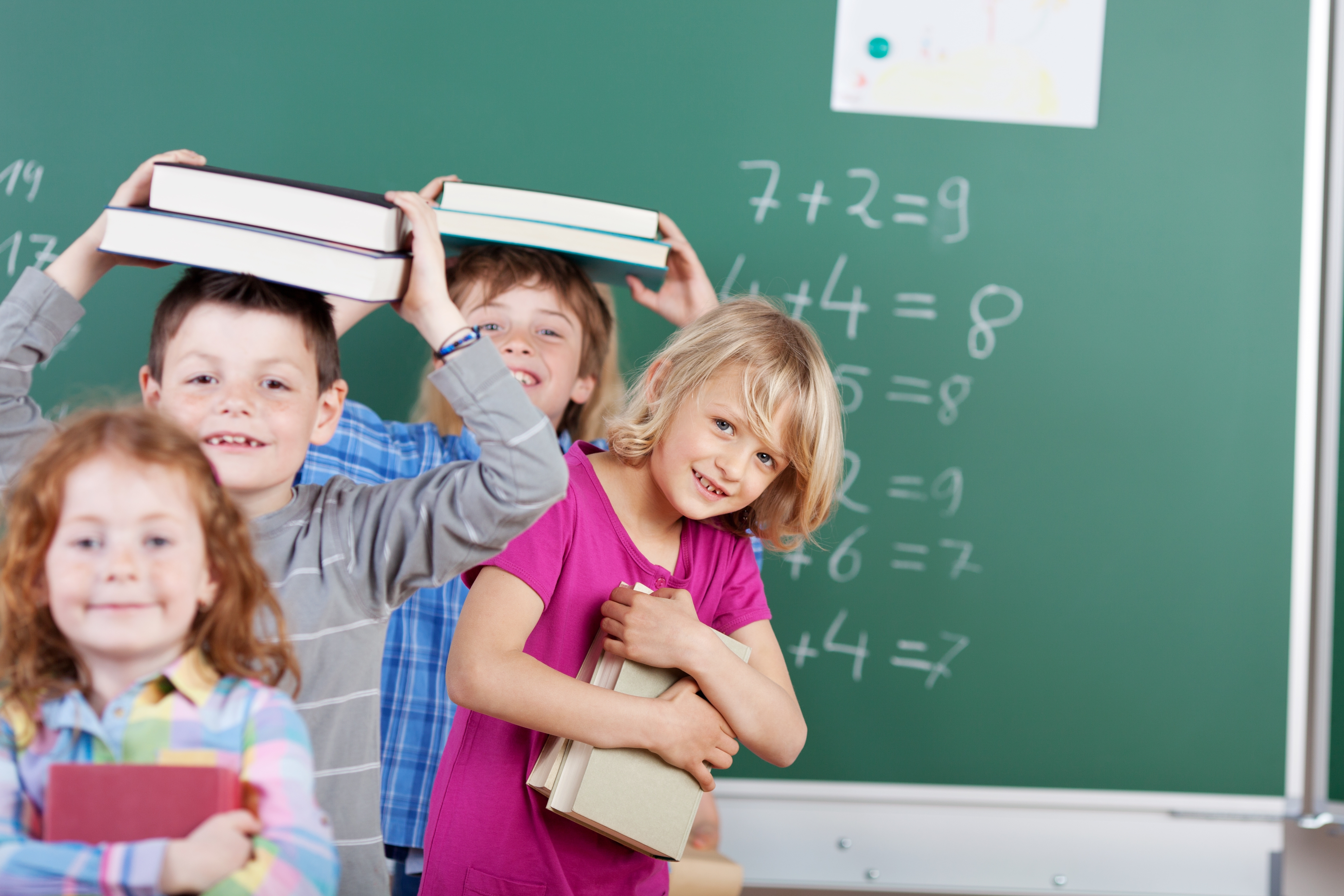 Schulkinder mit Büchern auf dem Kopf Schulkinder mit Büchern auf dem Kopf