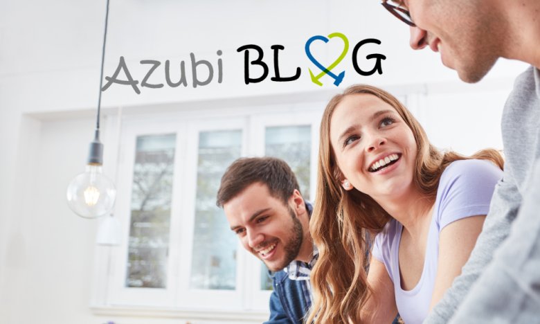 Auszubildende mit dem Logo des Azubi Blogs Das Bild zeigt eine Nahaufnahme von drei jungen Leuten in einem einem hellen Büro. Im Vordergrund, auf der rechten Seite, ist das Profil eines Mannes mit Brille zu sehen, der unscharf ist, aber eine graue Strickjacke trägt. In der Mitte des Bildes, nach links geneigt und ebenfalls aus der Nähe aufgenommen, befindet sich eine junge Frau mit langen, welligen, hellbraunen Haaren und einem hellvioletten T-Shirt. Sie lächelt und blickt nach oben und nach links, ihre Augen strahlen vor Freude. Sie trägt kleine weiße Ohrstecker. Links von ihr, im mittleren Hintergrund, sitzt ein junger Mann mit kurzen dunklen Haaren und einem Bart, der ein kariertes blau-weißes Hemd trägt. Er lächelt breit und schaut ebenfalls nach unten und nach links. Im Hintergrund ist eine weiße Wand und ein großes Fenster mit weißen Rahmen zu sehen, durch das eine verschwommene Baumlandschaft und Tageslicht dringt. Über den Köpfen der Personen schwebt in der oberen linken Ecke des Bildes ein Schriftzug in grauer Schrift, der "Azubi BLOG" lautet. Das Wort "BLOG" wird durch ein Symbol ersetzt, das ein Herz darstellt, das in zwei Hälften geteilt ist: eine blaue Hälfte mit einem Pfeil nach unten und eine grüne Hälfte mit einem Pfeil nach oben.