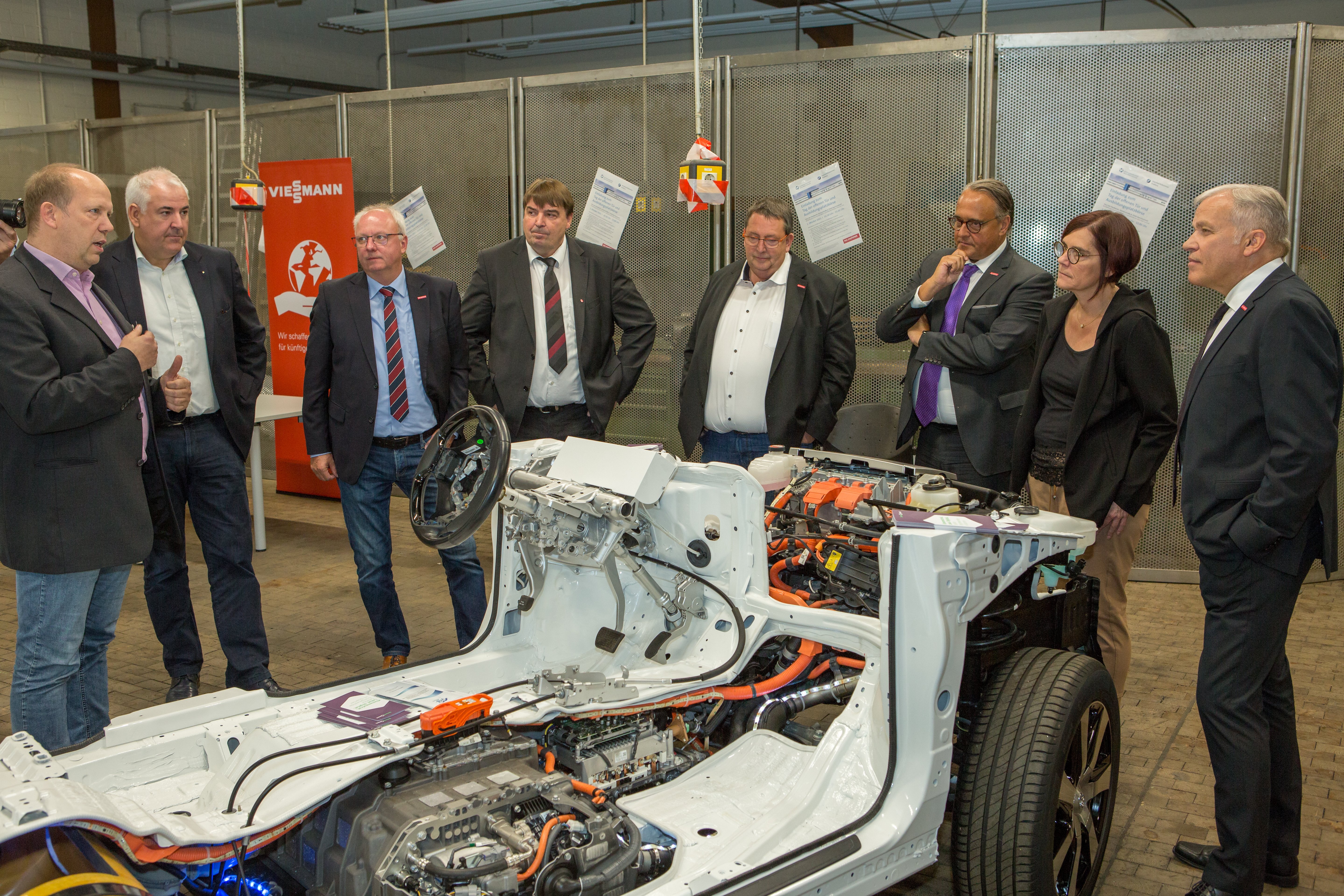 Staatssekretärin Petra Dick-Walther (MWVLW Rheinland-Pfalz) mit dem Präsidenten der HWK Koblenz, Kurt Krautscheid (rechts), dem Hauptgeschäftsführer der HWK, Ralf Hellrich (Dritter von rechts), dem HWK Vizepräsidenten, Mark Scherhag (Zweiter von links), dem SmartQuart-Projektleiter der Verbandsgemeindeverwaltung Kaisersesch, Uwe Diederichs-Seidel (links), und weiteren Interessierten. 