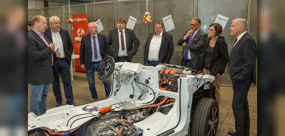 Staatssekretärin Petra Dick-Walther (MWVLW Rheinland-Pfalz) mit dem Präsidenten der HWK Koblenz, Kurt Krautscheid (rechts), dem Hauptgeschäftsführer der HWK, Ralf Hellrich (Dritter von rechts), dem HWK Vizepräsidenten, Mark Scherhag (Zweiter von links), dem SmartQuart-Projektleiter der Verbandsgemeindeverwaltung Kaisersesch, Uwe Diederichs-Seidel (links), und weiteren Interessierten. 